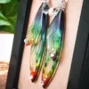 Gros plan des boucles artisanales longues en ailes de fée, couleur Arc-en-Ciel (multicolore vibrant)