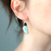 Boucles d’oreille artisanales asymétriques en ailes de fée, version iridescente, portées