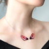 Collier artisanal en ailes de fée ouvertes, version Crépuscule, porté autour du cou