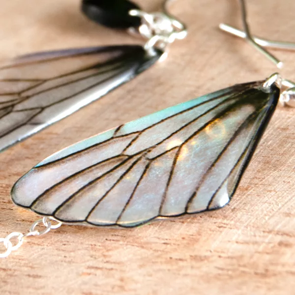 Gros plan sur les boucles d’oreille asymétriques Iridescent