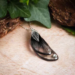 Ras de cou créateur noir avec pendentif ailé et breloque feuille