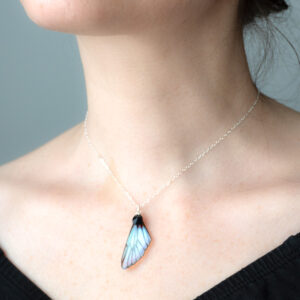 Ras de cou artisanal avec pendentif aile de fée iridescent porté autour du cou
