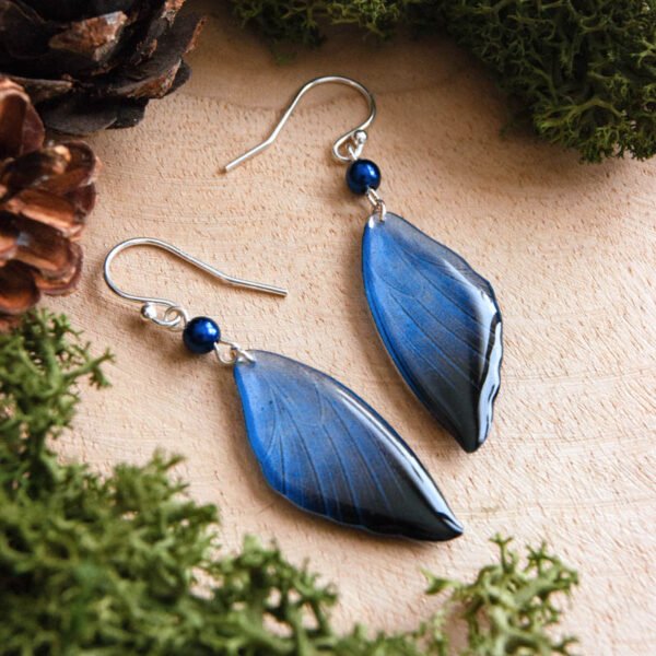 Boucles d’oreilles ailes de fée Cléophée en résine bleu translucide avec perle nacrée.