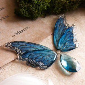 Collier ailes de fée bleu Lioraëlys sur fond végétal
