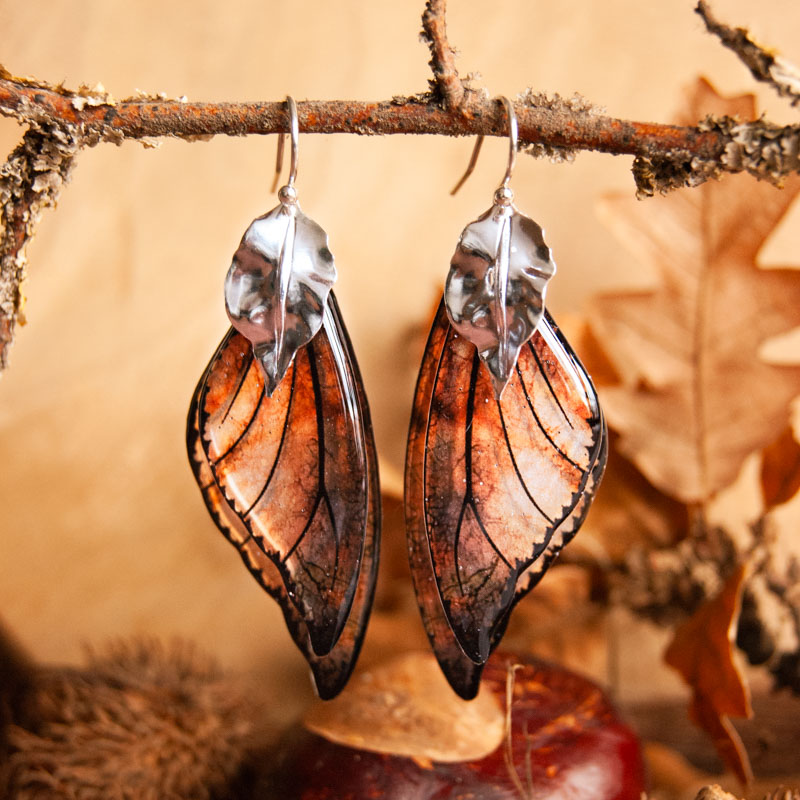 Boucles Équinoxe créées avec les ailes de la fée Sylmeria, présentées sur fond naturel
