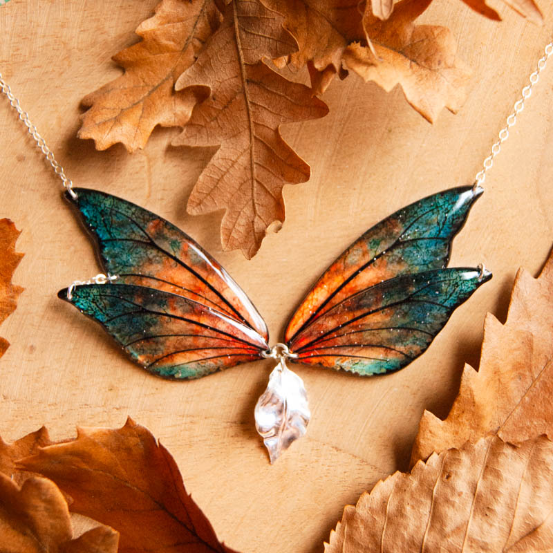 Collier Feu Follet en ailes de la fée Sylmeria présenté dans un décor automnal