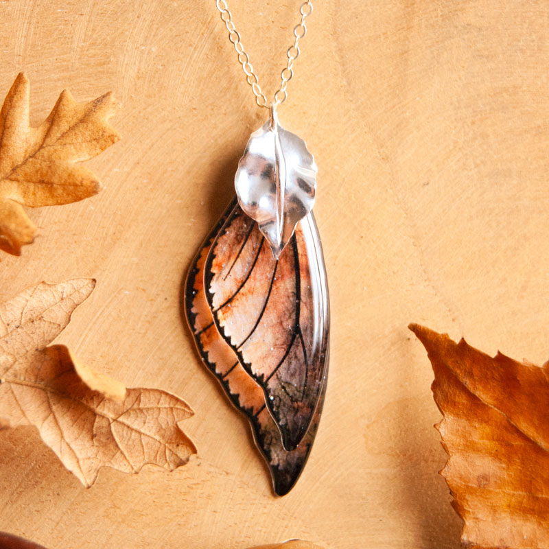 Sautoir Équinoxe fabriqué avec les ailes de la fée Sylmeria, présenté dans un décor automnal