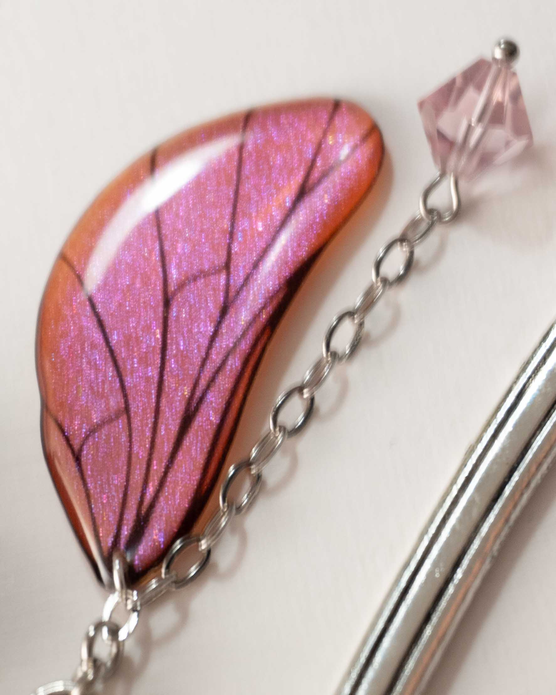 Marque-page féerique avec aile scintillante aux reflets saumon et rose, chaînette et perle rose pâle