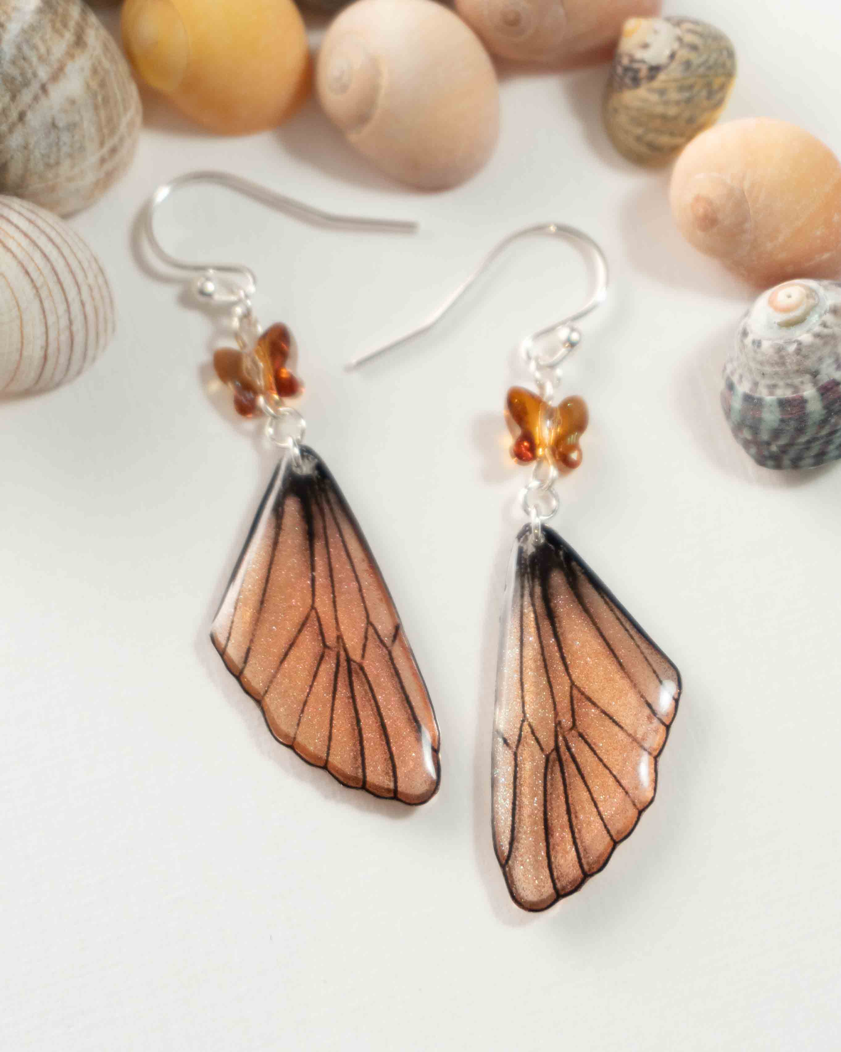Boucles d’oreilles féeriques aux ailes mordorées, aux reflets cuivre et verts, avec perles papillon ambrées