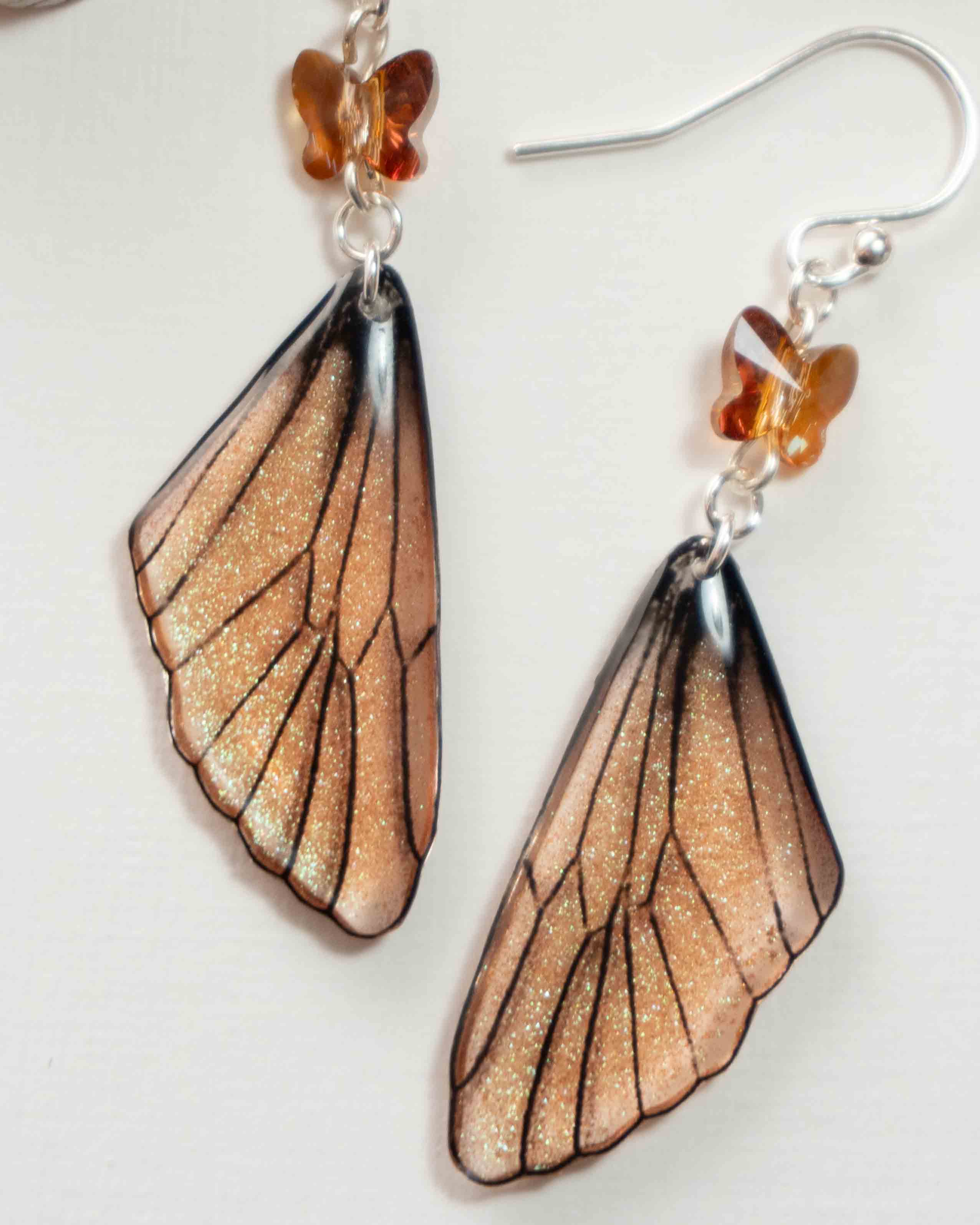 Boucles d’oreilles féeriques aux ailes mordorées, aux reflets cuivre et verts, avec perles papillon ambrées