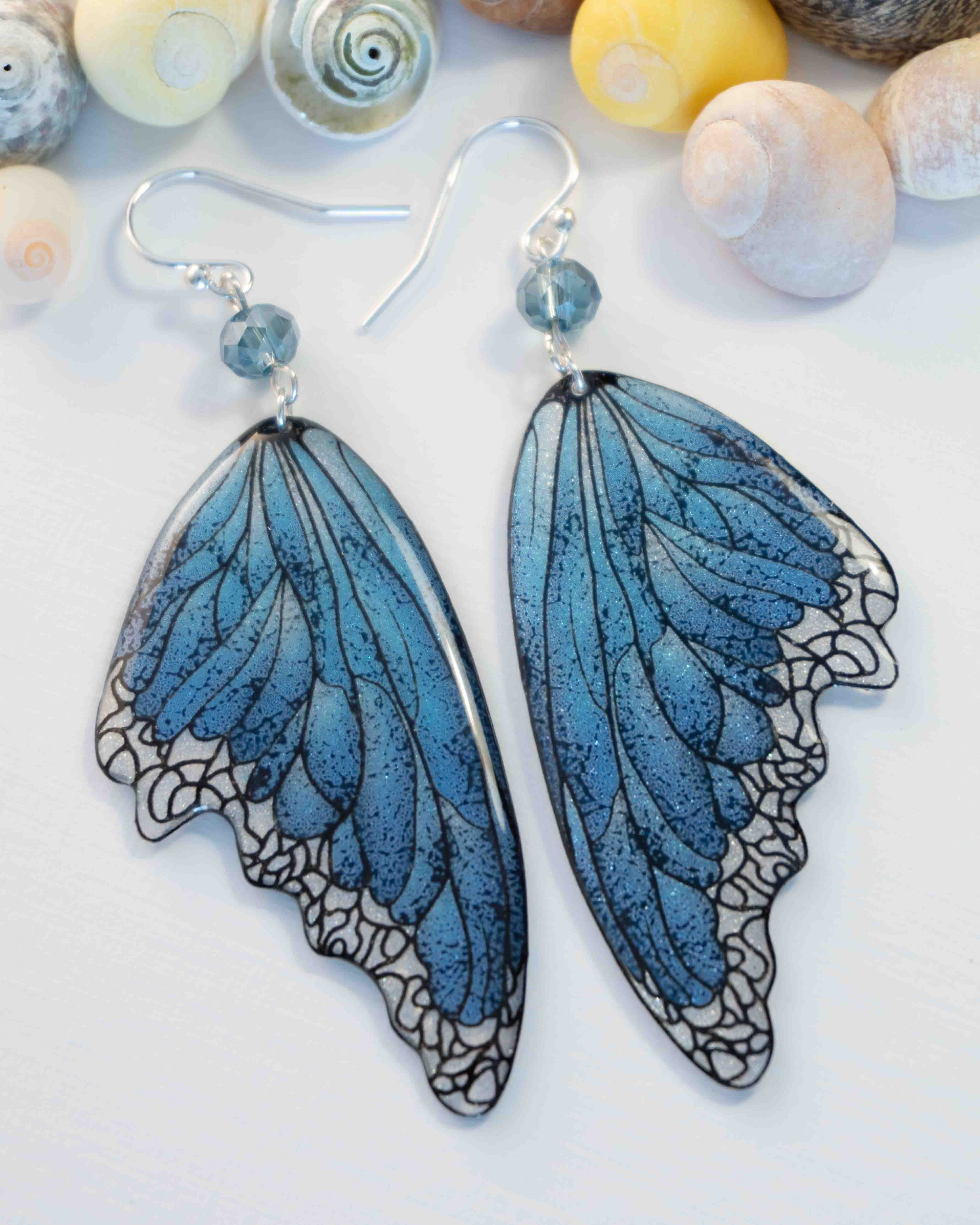 Boucles d’oreilles féeriques Lioraëlys aux grandes ailes bleues et blanches avec perles en verre bleues