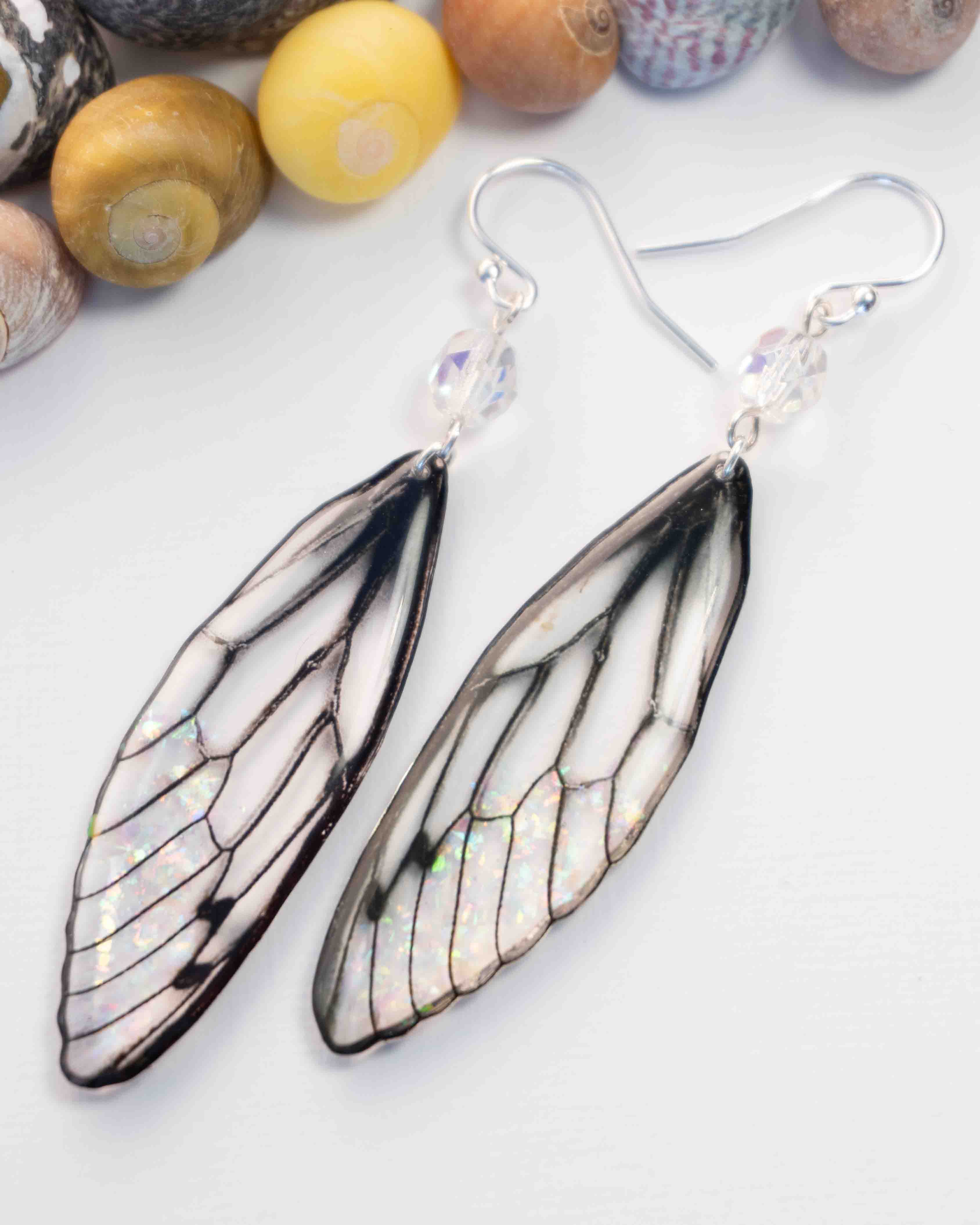 Boucles d’oreilles féeriques Rhoswen aux ailes blanches translucides pailletées avec perles aurore boréale