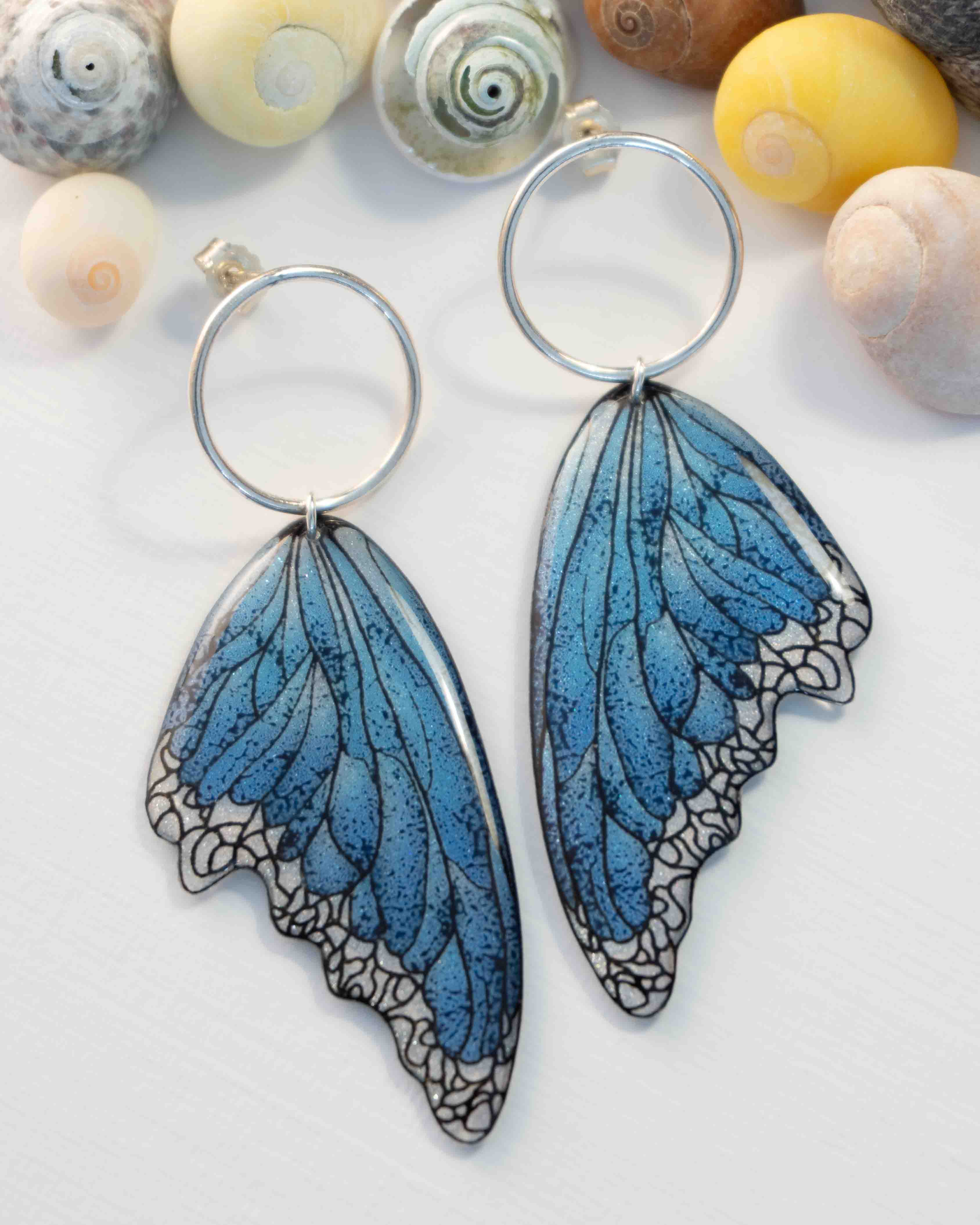 Boucles d’oreilles féeriques Lioraëlys sur clous, avec petites ailes bleues en résine