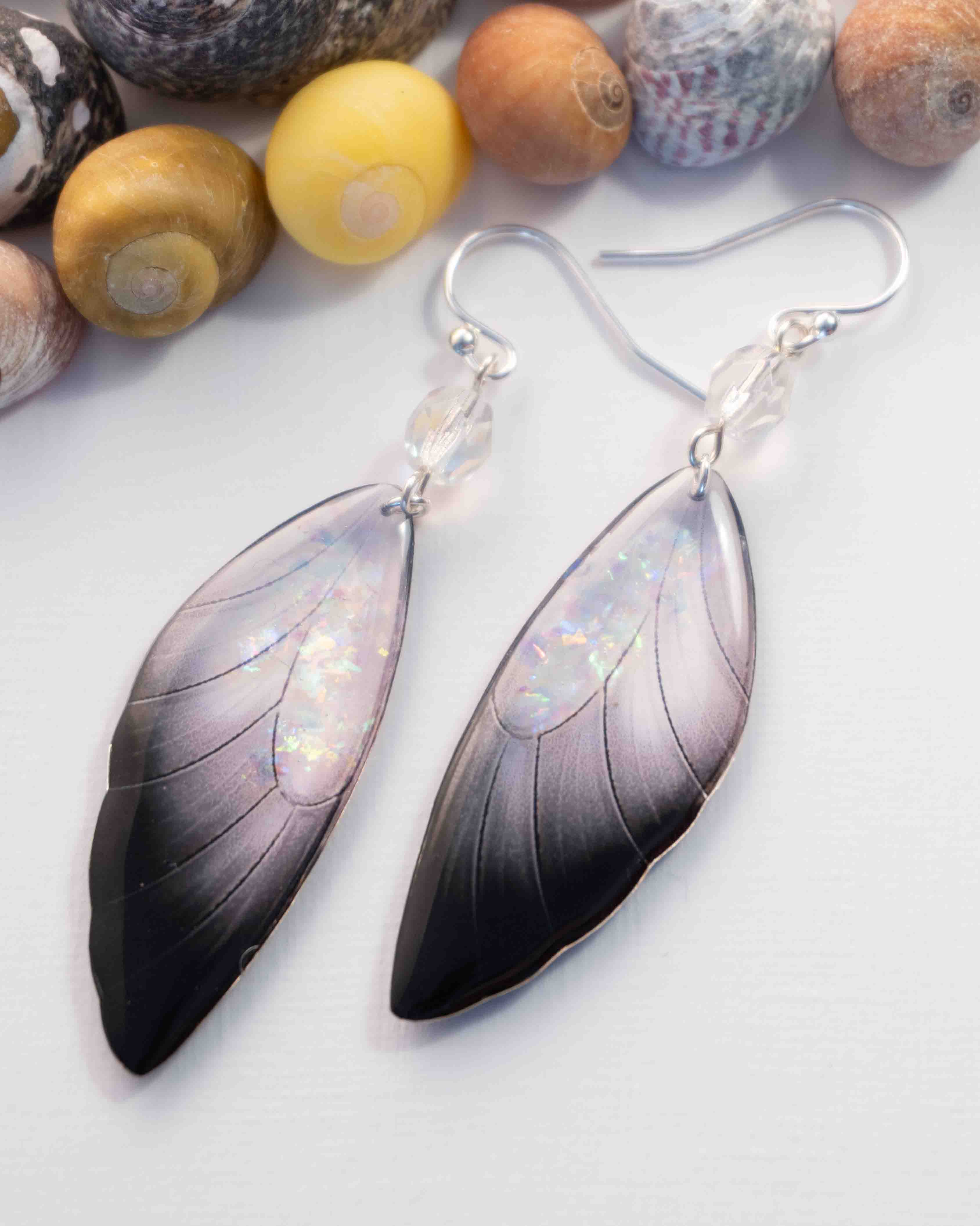 Boucles d’oreilles féeriques Cléophée aux ailes blanches et noires ornées de paillettes aurore boréale
